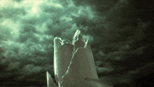 a broken candle against a cloudy sky