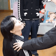 a man is putting his hand on a woman 's shoulder in a living room .