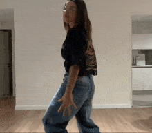 a woman wearing jeans and a black shirt with the word tiger on the back