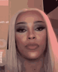 a close up of a woman 's face with a pink background .