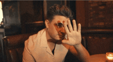 a man in a white shirt sits at a table in a diner