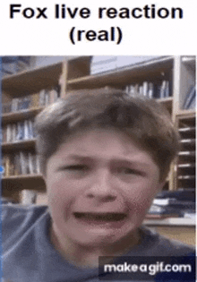 a boy is crying in front of a bookshelf and a sign that says `` fox live reaction ( real ) '' .