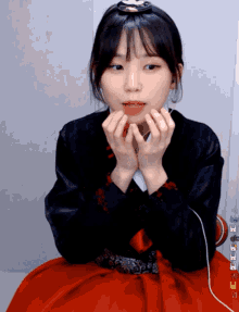 a girl with a crown on her head is making a heart shape with her hands