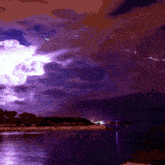 a purple lightning storm over a body of water at night