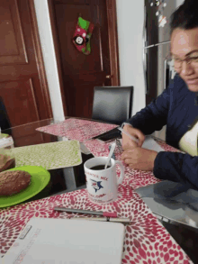 a man sitting at a table with a mug that says texas mills on it