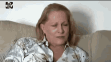 a woman is sitting on a couch crying .