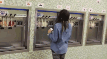 a woman stands in front of a frozen yogurt machine that says ' 88 ' on it