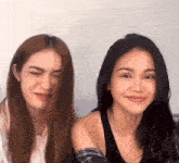 two women are standing next to each other and smiling .