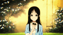 a girl with long black hair is holding a flower in her mouth