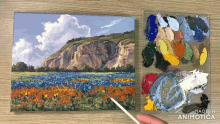 a painting of a field of flowers next to a palette