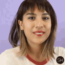 a close up of a woman 's face with a sh logo on the bottom