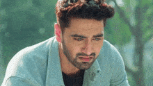 a man with a beard is crying and looking down