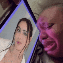 a man is crying while looking at a photo of a woman