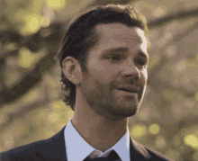 a man in a suit and tie looks at the camera