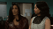 two women are standing next to each other and one has red lipstick on
