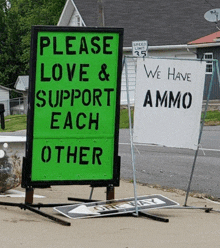 a green sign that says please love & support each other