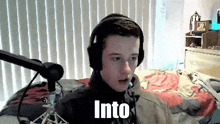 a boy wearing headphones is sitting in front of a microphone with the word into written on the bottom