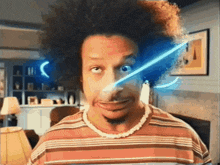 a man in a striped shirt has a light coming out of his eye