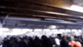 a blurry picture of a crowd of people standing in a room