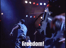 a man in a denim vest singing into a microphone with the word freedom written below him