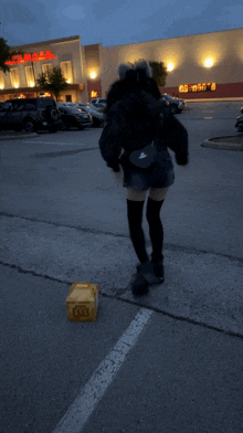 a person standing in a parking lot in front of a cinemas