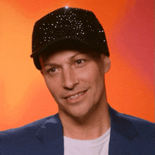 a man wearing a black hat with rhinestones on it