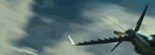 a fighter jet is flying through a cloudy sky with its wings spread out .