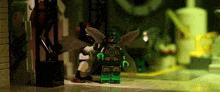 a green lego figure with wings is standing on a tiled floor in a dark room