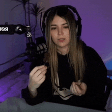 a woman wearing headphones is holding a piece of chocolate in front of a microphone that says vox on it