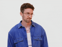 a man wearing glasses and a denim shirt
