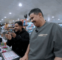 two men are standing in a store and one has a shirt that says miller on it