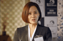 a woman in a suit stands in front of a sign that says ' buck ' on it
