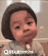 a baby wearing a hat and a star tamil chat logo behind him