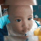 a close up of a baby 's face with big blue eyes