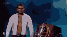 a man in a white jacket stands in front of a trophy with the letters usa on it
