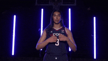 a woman is wearing a uconn jersey with the number 8 on the front