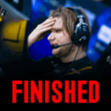 a man wearing headphones holds his hand to his face in front of the word finished