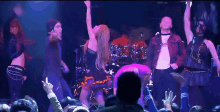 a group of people dancing on a stage in front of a crowd