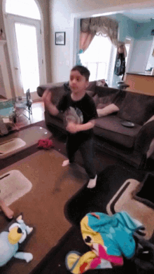 a young boy is dancing in a living room with stuffed animals on the floor