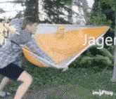 a man is holding a large yellow object with the word jager on it