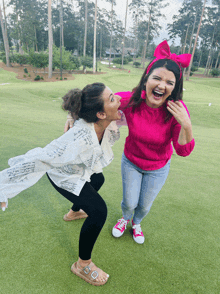 two women are posing for a picture and one is wearing a pink sweater