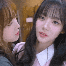 two girls are looking at each other and one has a pink shirt on
