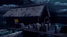a house with a thatched roof sits next to a body of water