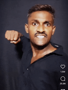 a man in a black shirt is making a funny face with his fist in the air