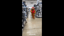 a gingerbread man is dancing in a store with a santa hat on .