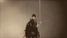 a black and white photo of a man with a sword