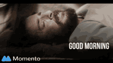 a man with a beard is laying down with his eyes closed and says good morning