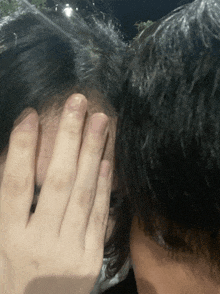 a person covering their face with their hand