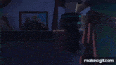 a person is standing in a dark room holding a trophy in their hand .