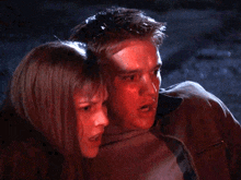 a man and a woman are standing next to each other and their faces are red